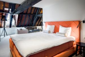 a bedroom with a large bed with an orange headboard at Hampshire Hotel - 's Gravenhof Zutphen in Zutphen