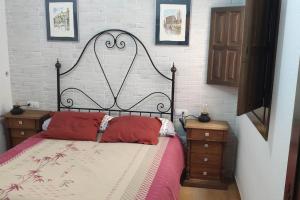 een slaapkamer met een bed met rode kussens erop bij RECONECTA CONTIGO MISMO in Carataunas
