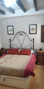 een slaapkamer met een groot bed met rode kussens bij RECONECTA CONTIGO MISMO in Carataunas