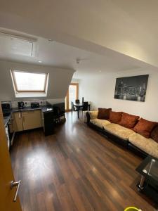 een woonkamer met een bank en houten vloeren bij spacious 2 bed apartment in Norwich city centre in Norwich