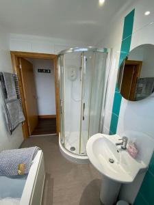 a bathroom with a shower and a white sink at spacious 2 bed apartment in Norwich city centre in Norwich
