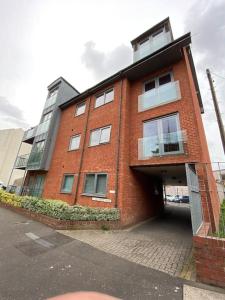 un grand bâtiment en briques rouges avec un garage dans l'établissement spacious 2 bed apartment in Norwich city centre, à Norwich