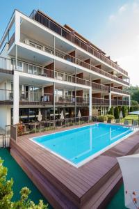 an apartment building with a swimming pool and a resort at Feel Good Apartments in Krumpendorf am Wörthersee