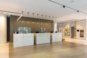 贝尔格莱德Hotel Mona Plaza的大堂设有白色大理石墙壁和酒吧