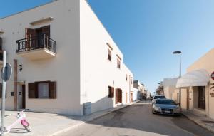 a car parked on a street next to a white building at Angolo Arancio Bed & Breakfast in San Vito lo Capo