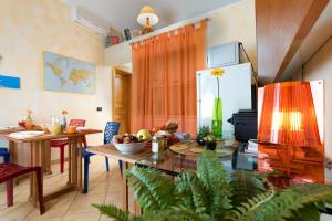 a kitchen with a table and a dining room at Angolo Arancio Bed & Breakfast in San Vito lo Capo