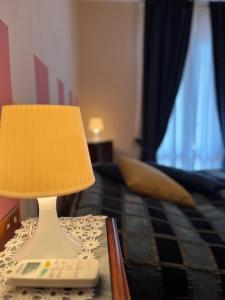 una lámpara sentada en una mesa junto a una cama en Tuscan Room en San Quirico dʼOrcia