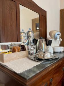 un mostrador con una caja de comida y un espejo en Tuscan Room en San Quirico dʼOrcia