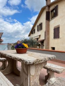 una mesa de piedra con un tazón de flores. en Tuscan Room en San Quirico dʼOrcia