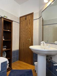 baño con lavabo y puerta de madera en Tuscan Room en San Quirico dʼOrcia