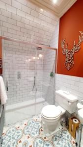 a bathroom with a toilet and a shower and a tub at Dungallan Country House Bed & Breakfast in Oban