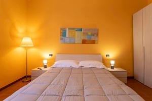 um quarto com uma cama grande e paredes amarelas em The Novara Gateway - appartamento Novara em Novara