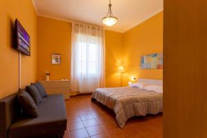 a bedroom with a bed and a couch and a television at The Novara Gateway - appartamento Novara in Novara