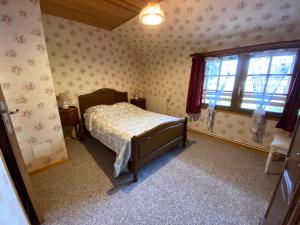 a bedroom with a bed and a window at Le Val Godard in Fresnay-le-Samson