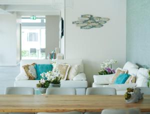 a living room with white couches and a wooden table at Junior Family Hotel in Cavallino-Treporti