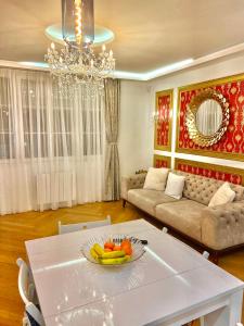 uma sala de estar com uma mesa branca com uma taça de fruta em Alexandru Home em Boissy-Saint-Léger