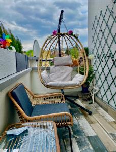 une terrasse couverte avec une balançoire et une chaise sur un balcon dans l'établissement Alexandru Home, à Boissy-Saint-Léger