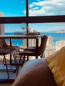 Pokój ze stołem i krzesłami oraz widokiem na ocean w obiekcie GEMELOS 15 TURIS - PREMIUM Apartamentos w mieście Benidorm