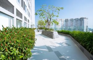 胡志明市的住宿－Jessie Apartment - Infinity pool - Rivergate Residence，一条种植了植物的建筑旁的走道