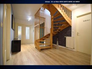 a hallway with a wooden staircase in a house at Aux Souvenirs d'Anaëlle gîtes 5 personnes in Sainte-Marie-aux-Mines