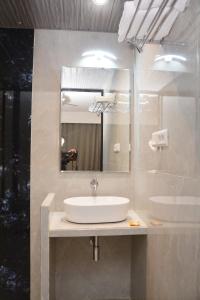 a bathroom with a sink and a mirror at HOTEL SAI PALKHI NIWARA in Shirdi