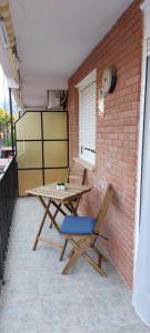 a wooden table and a chair on a patio at Apartamento Ferrandis Benicasim in Benicàssim