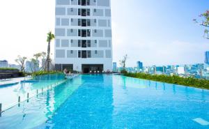 a large swimming pool in front of a tall building at Oui Oui La Piscine Apartment In SaiGon in Ho Chi Minh City