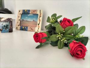 une table avec des roses, une photo et une caméra dans l'établissement Al vecchio Mulino, à Lastra a Signa