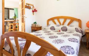 a bedroom with a wooden bed with a white and purple blanket at Casa GRENADO in Vallehermoso