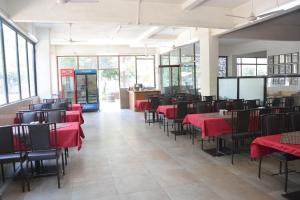 a dining room with red tables and chairs at Hotel Sai Palkhi Niwara in Shirdi