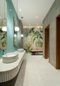 a bathroom with two sinks and a large mural at Greenpark Bengaluru in Bangalore