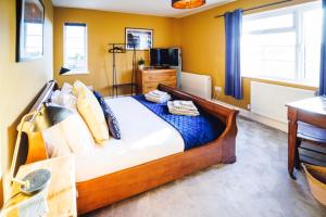 MillbrookにあるNew Wiggle Farmhouseの黄色い壁のベッドルーム1室(大型ベッド1台付)