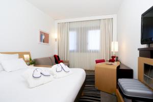 um quarto de hotel com duas camas e uma televisão em Novotel Milano Nord Ca' Granda em Milão