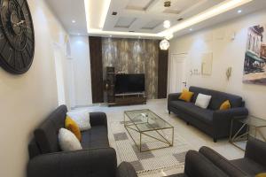 راحتك - إقامة وفخامة في مكة المكرمة: غرفة معيشة بها كنبتين وتلفزيون