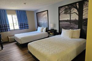 una habitación de hotel con 2 camas y un cuadro en la pared en Super 8 by Wyndham Estherville, en Estherville