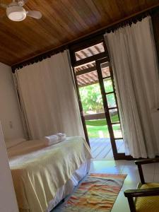 Schlafzimmer mit einem Bett und einer Glasschiebetür in der Unterkunft Suspiro da Bahia Pé na areia in Salvador