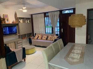 ein Wohnzimmer mit einem Tisch und einem Sofa in der Unterkunft Suspiro da Bahia Pé na areia in Salvador