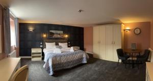 a bedroom with a bed and a table and chairs at Alexander Park B&B in Ledbury