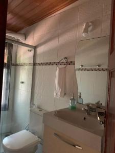 W łazience znajduje się toaleta, umywalka i lustro. w obiekcie Suspiro da Bahia Pé na areia w mieście Salvador