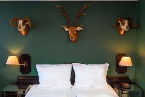 a bedroom with a bed with deer heads on the wall at Wyndham Garden Donaueschingen in Donaueschingen