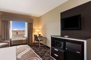 a hotel room with a bed and a flat screen tv at Quality Inn & Suites Pearl-Jackson in Pearl