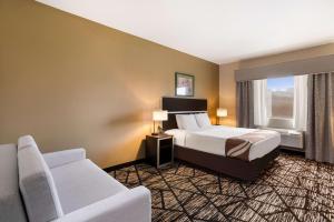 a hotel room with a bed and a couch at Quality Inn & Suites Pearl-Jackson in Pearl +17 photos