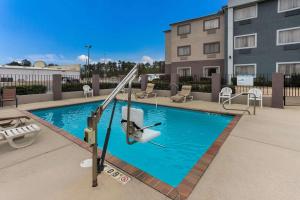 a swimming pool with a slide in front of a building at Quality Inn & Suites Pearl-Jackson in Pearl
