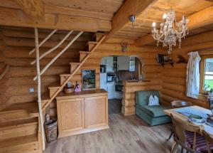 a dining room and kitchen in a log cabin with stairs at Schlossalm Ferienwohnungen in Brannenburg