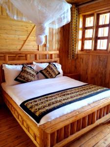 a bedroom with a wooden bed in a cabin at Keije Resort Bunyonyi in Kabale