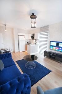 a living room with a blue couch and a table at King Suite MS5 in Esenyurt