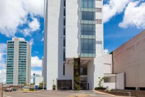 a tall white building with two tall buildings at Wyndham Puebla Angelopolis in Puebla