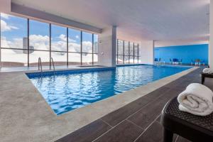 a swimming pool with a view of a building at Wyndham Puebla Angelopolis in Puebla