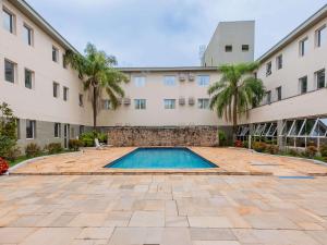 a swimming pool in front of a building at Ibis Styles Campinas Alphaville in Campinas