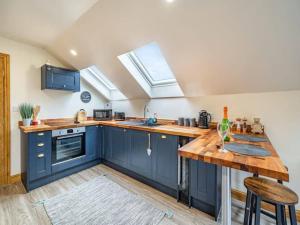 a kitchen with blue cabinets and a wooden table at Rita's Roost, Lancs, tranquil with amazing views in Burnley